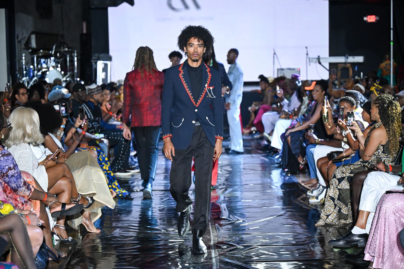 Model in a navy red-trimmed blazer mid-runway at Ankara Festival LA