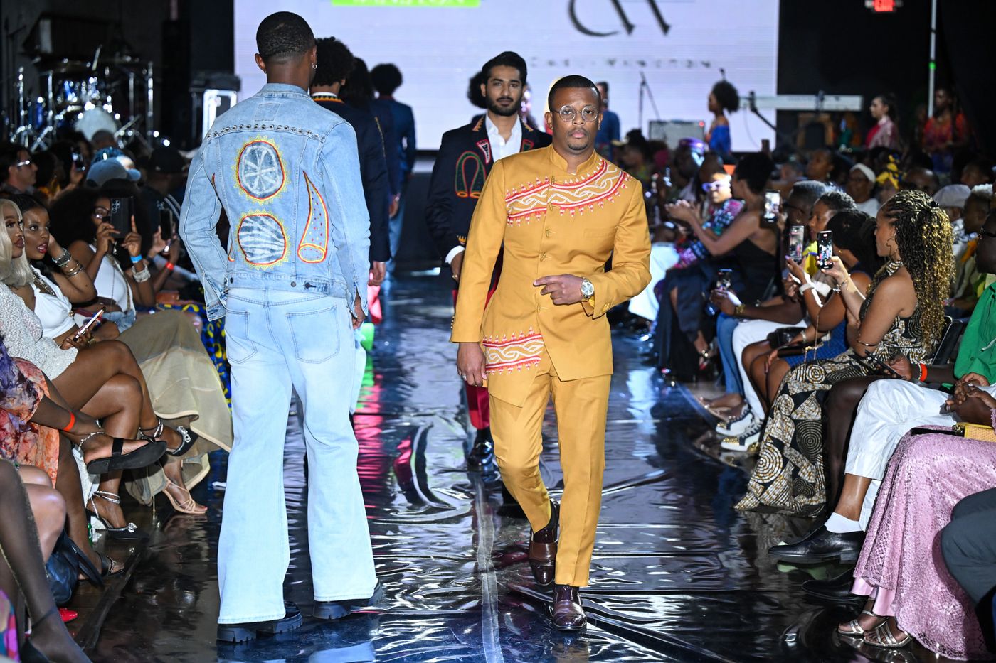 Model in a gold embroidered suit walking the AFLA runway